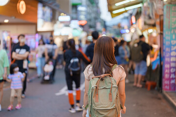 woman traveler visiting in Taiwan, Tourist with bag sightseeing and Shopping in Shilin Night Market, landmark and popular attractions in Taipei city. Asia Travel and Vacation concept