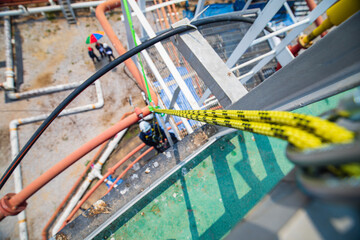 Closeup male worker standing on tank male worker height roof tank knot carabiner rope access safety