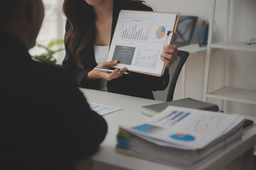 Financial analysts analyze business financial reports on a digital tablet planning investment project during a discussion at a meeting of corporate showing the results of their successful teamwork.