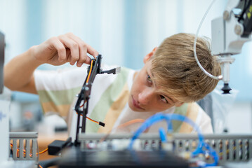 Boy male teen child concentrate enjoy Machine Learning Robot is Moving Under Control robot coding at technology stem class, stem education robot for digital automation artificial intelligence ai © BESTIMAGE