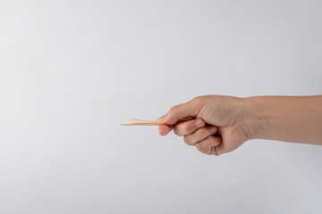 Hand with a toothpick isolated on white background
