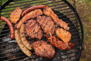 various meat and sausages on the charcoal grill