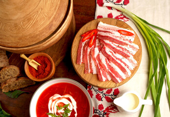 Traditional Ukrainian borsht, red vegetable soup or borscht with smetana on wooden background....