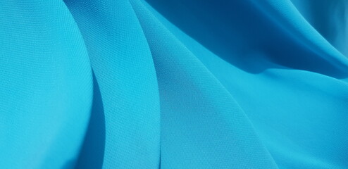 Wavy blue chiffon, in folds (macro fabric, texture).
