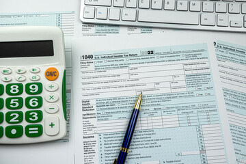 Blank 1040 US Individual income tax return form 2022 with pen calculator and computer keyboard