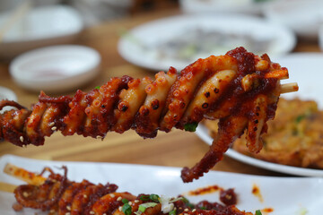 Grilled Whole Octopus is a traditional Korean dish where whole octopus is skewered, rolled, coated with sauce, and grilled.
