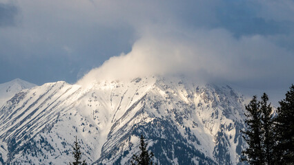 Fototapeta na wymiar snowy mountain peaks in the clouds. cloudy weather in the mountains. snow cliffs. beautiful clouds