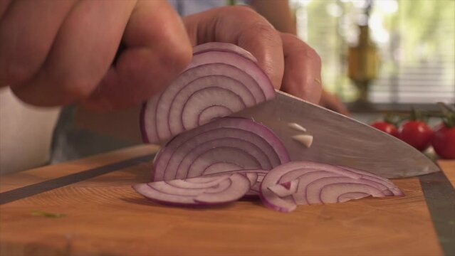 The cook cuts the onion