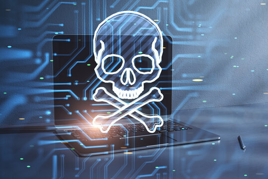 Close up of laptop with glowing skull hologram on blurry background. Hacker system or cyber attack concept. Double exposure.