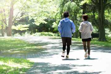 Couple running in a beautiful park with fresh greenery No back view Wide angle
