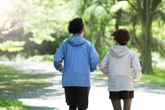 Couple running in a beautiful park with fresh greenery, no back view face