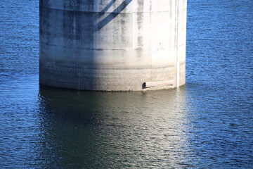 Cement Pilon in Water on Blue Lake