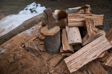 Still life. View from above of an old wooden handle ax in a stump. Cutting firewood for the winter. Chopping a tree in a coniferous forest. Renewable resource of energy. Rustic nature background