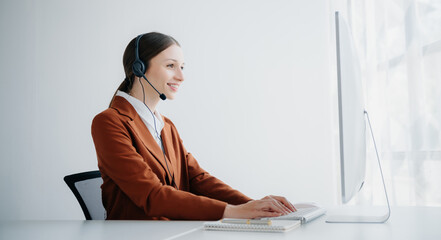 Serious call center operator in wireless headset talking with customer, woman in headphones with...