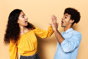 Profile view image of two best friends female and male high-fiving to each other standing against...