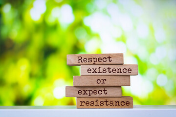 Wooden blocks with words 'Respect existence or expect resistance'.