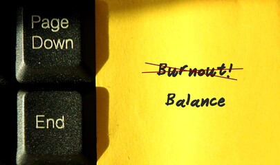 End letter on keyboard and yellow paper with text written BURNOUT and BALANCE ,concept of hard...