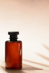 Abstract cosmetic bottle at beige background with palm leaf shadow. Shampoo, bath gel or lotion aesthetic image