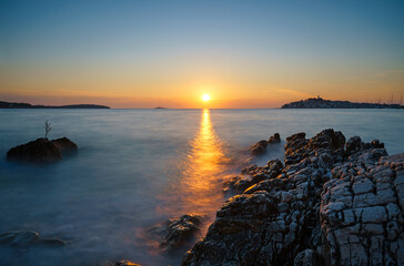 Sunset at the sea in Primošten, Croatia, with rocks in the foreground