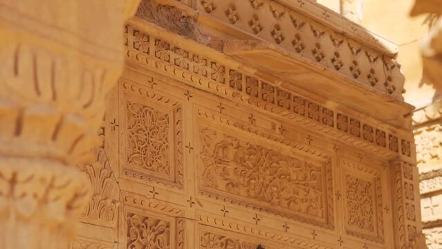 Closeup shot of carvings on the top portion of the chattri dome cenotaph at Bada Bagh in Jaisalmer, Rajasthan, India. Carvings on top of the structure made out of sandstone. Ancient carving on dome. 