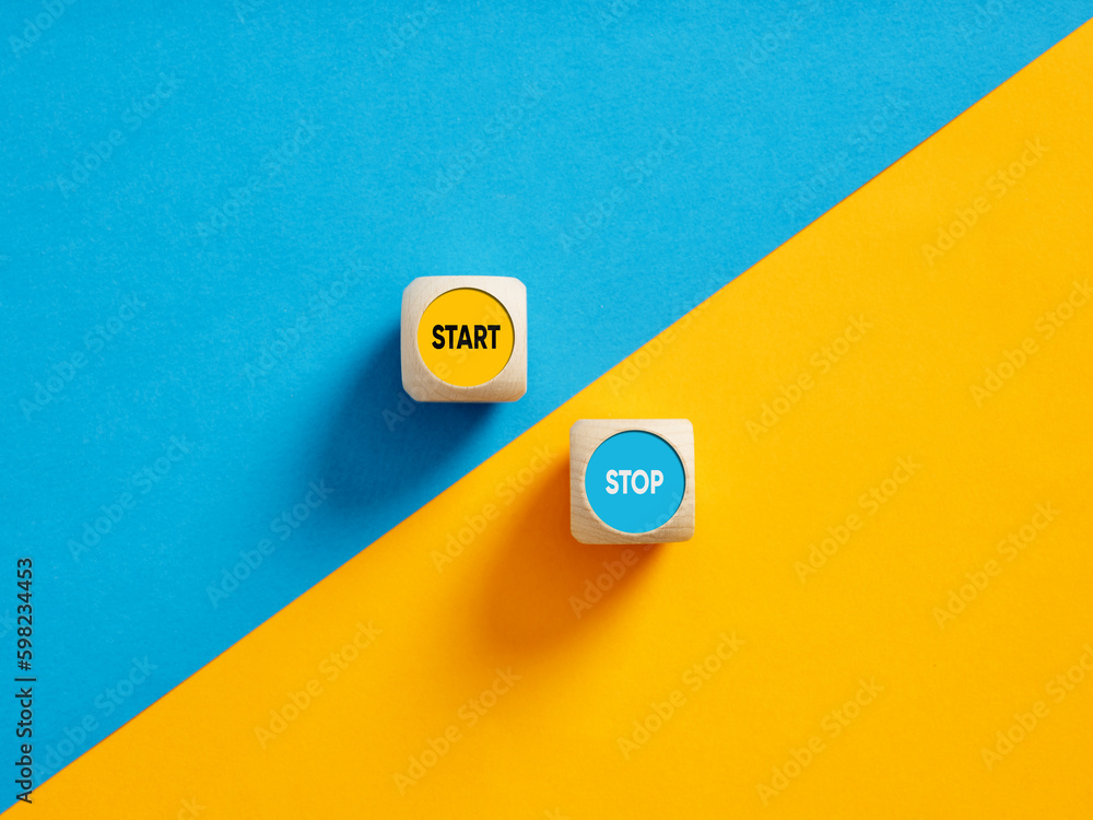 Poster the words start and stop on wooden cube push buttons. goal, strategy and decision to take action in 