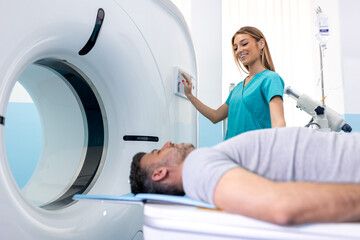 Female Doctor Looking At Patient Undergoing CT Scan. Doctor in uniform using tomography machine...