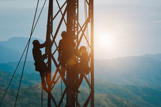 silhouette workers on background of construction crews to work on high ground heavy industry and safety concept. Construction of the extension of high-voltage towers on blurred nature background.