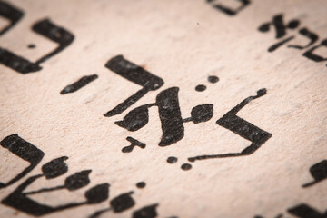 Closeup of hebrew word in Torah page. English translation is name Leah. Unloved wife of the Biblical patriarch Jacob. Selective focus.