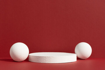 Geometric white podium with balls on an abstract red background. Empty scene for the product...