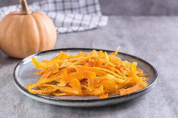 Appetizing vegetarian dessert pumpkin chips on a plate on the table