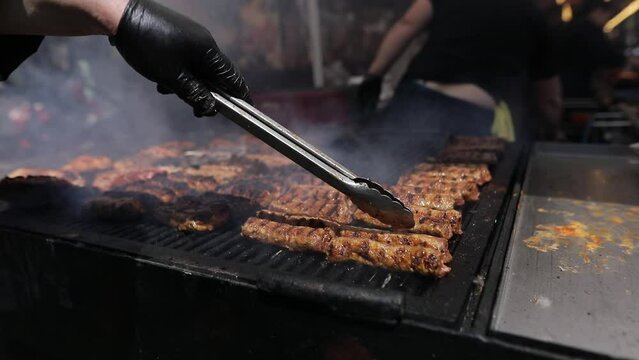 Romanian traditional mici (mititei), grilled ground meat rolls in cylindrical shape and other meats on the barbecue grill.