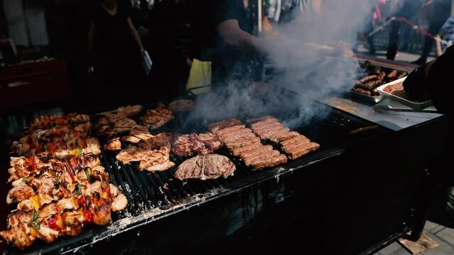 Romanian traditional mici (mititei), grilled ground meat rolls in cylindrical shape and other meats on the barbecue grill.