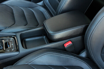 Obraz premium Armrest in the car for driver. Car armrest. Car armrest opened. Opened armrest in the car for driver.