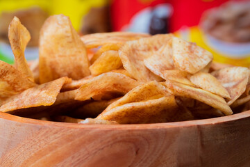 Banana chips with a sweet and salty taste made from fried raw bananas in a wooden bowl. Traditional snacks