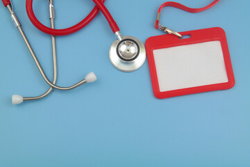 Red stethoscope and red badge on blue background. Accreditation for medical events and meetings concept.