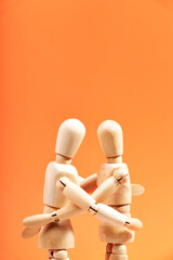 Close-up of a couple of Dummies embracing on an orange background. Love concept