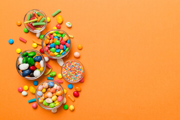 Fototapeta na wymiar different colored round candy in bowl and jars. Top view of large variety sweets and candies with copy space