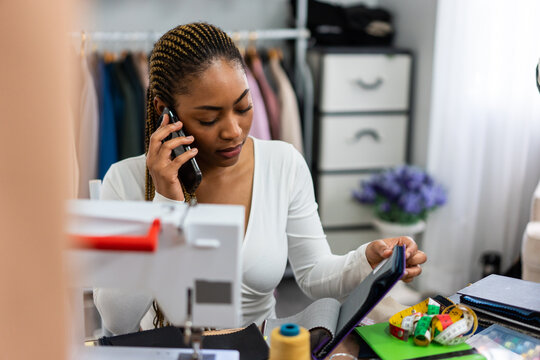 African American women fashion designer working in a tailoring atelier. 