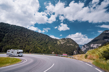 Caravan car travels on the highway in Alp Mountains. Traveling concept. Camper vans.