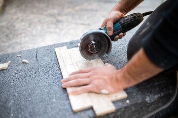 Fototapeta na wymiar Closeup of a worker use cutting machine to cut a ceramic tile