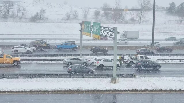 wrecker attending two vehicle nose-to-tail accident during snow storm on highway