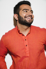 Indian man smiling and looking away while standing isolated over white background