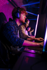 Team of gamers playing online game on championship in cybersport club