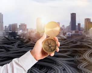 Businessman holds a compass to help himself to find the correct way