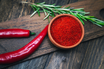 Paprika, chili peppers and rosemary on a wooden board.