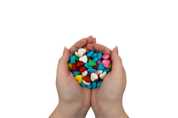 A handful of multi-colored heart-shaped sweets in hands on a transparent background