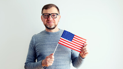 Man with USA flag. Middle-aged man with glasses on a gray background.