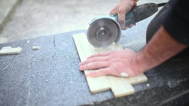 Tiler at work. Closeup of a worker use cutting machine to cut a ceramic tile