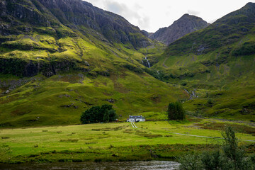 Glencoe landscape with waterfall and house. Highlands, Scotland, Great Britain, United Kingdom.