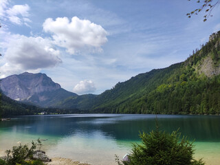 Дake in the mountains. Langbathsee lake in Austrian mountains. Pure water. Blue sky and white clouds. Summer day on a lake. Green montain. Ecotourism. Hiking place.